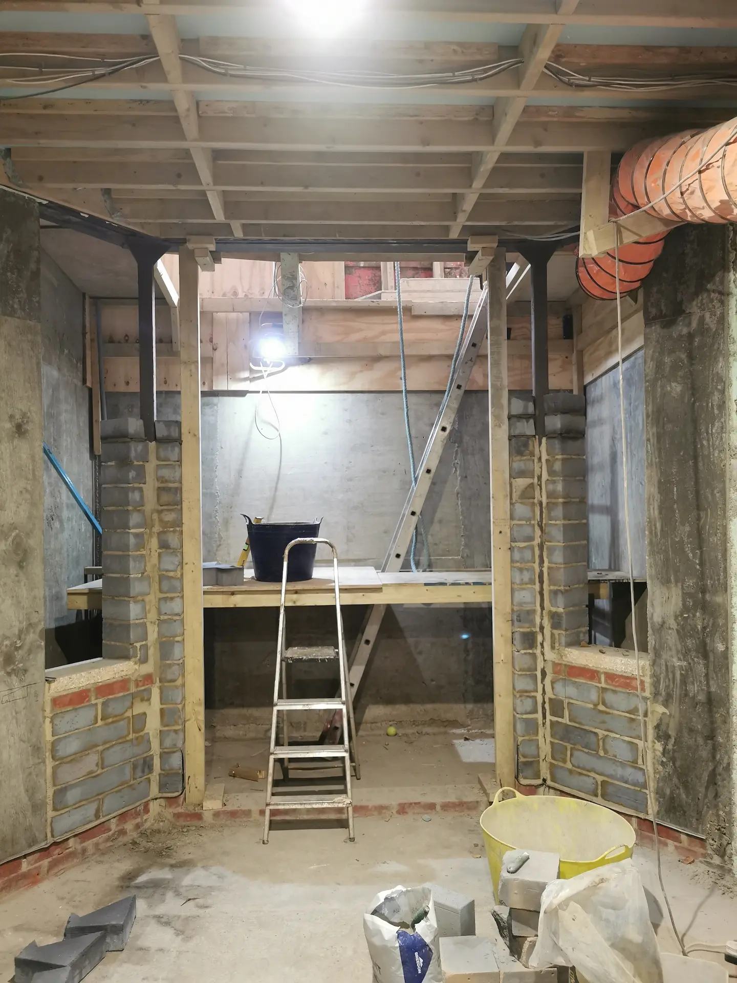 Basement construction in Chiswick with a bay windows and door designed to maximize natural light coming into the basement