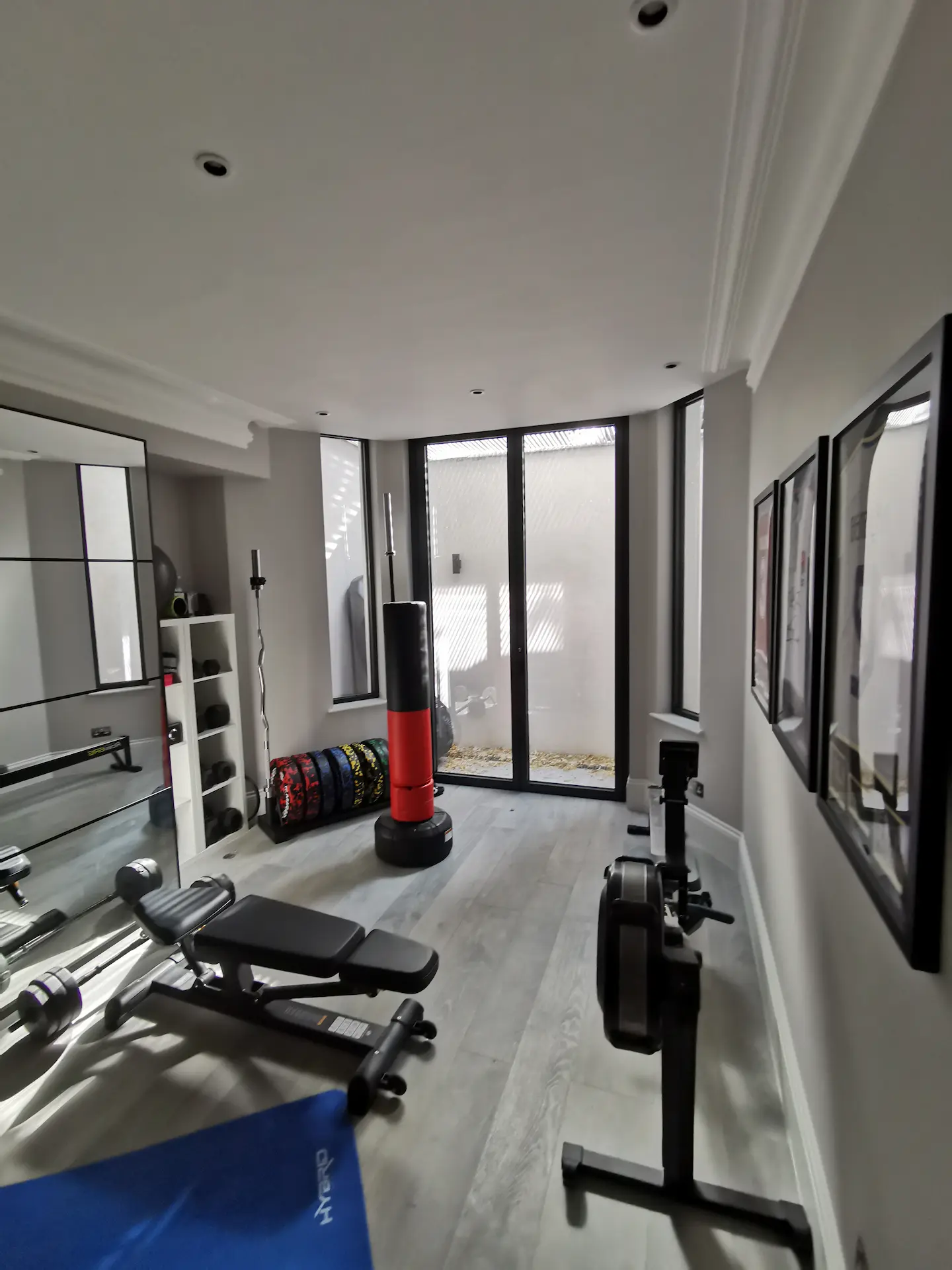 Finished basement gym in Chiswick home with tall windows to maximize natural light