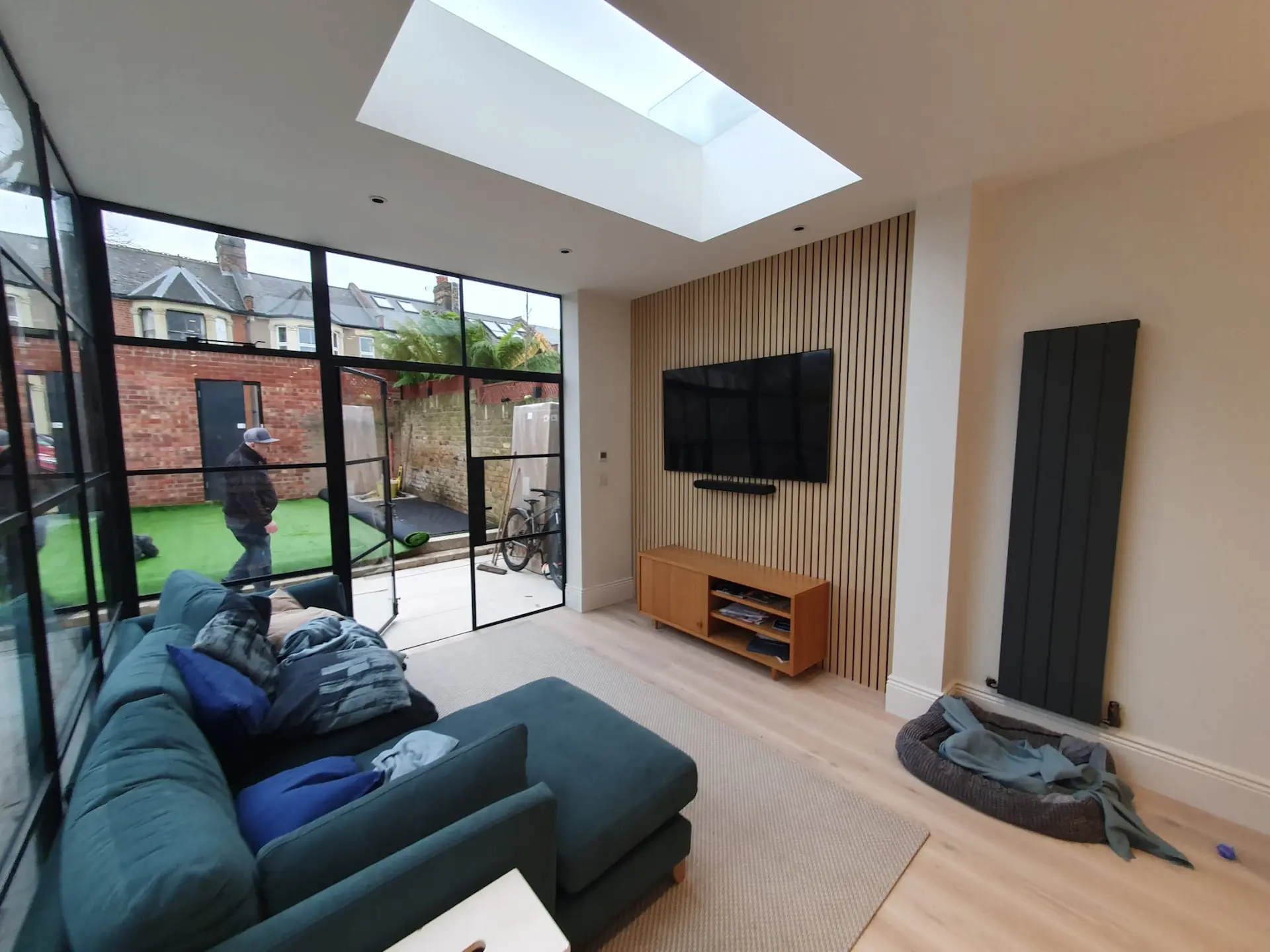 Finished interior of the rear extension, showcasing the TV area, skylight, and Crittall door in Chiswick