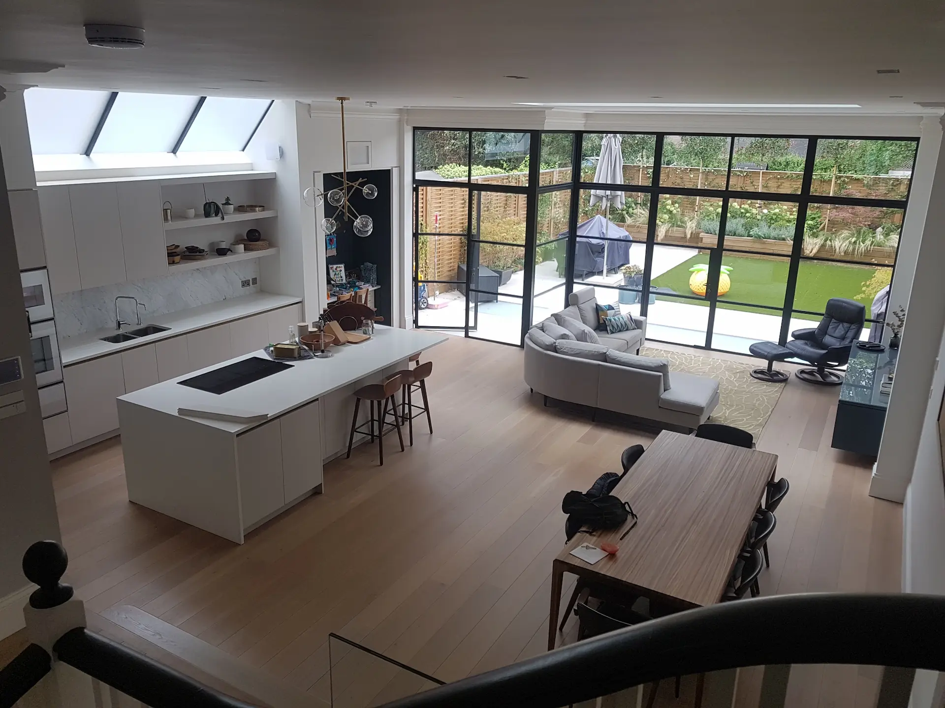 Open-plan kitchen and living space in refurbished Chiswick home with roof lights and Crittall doors