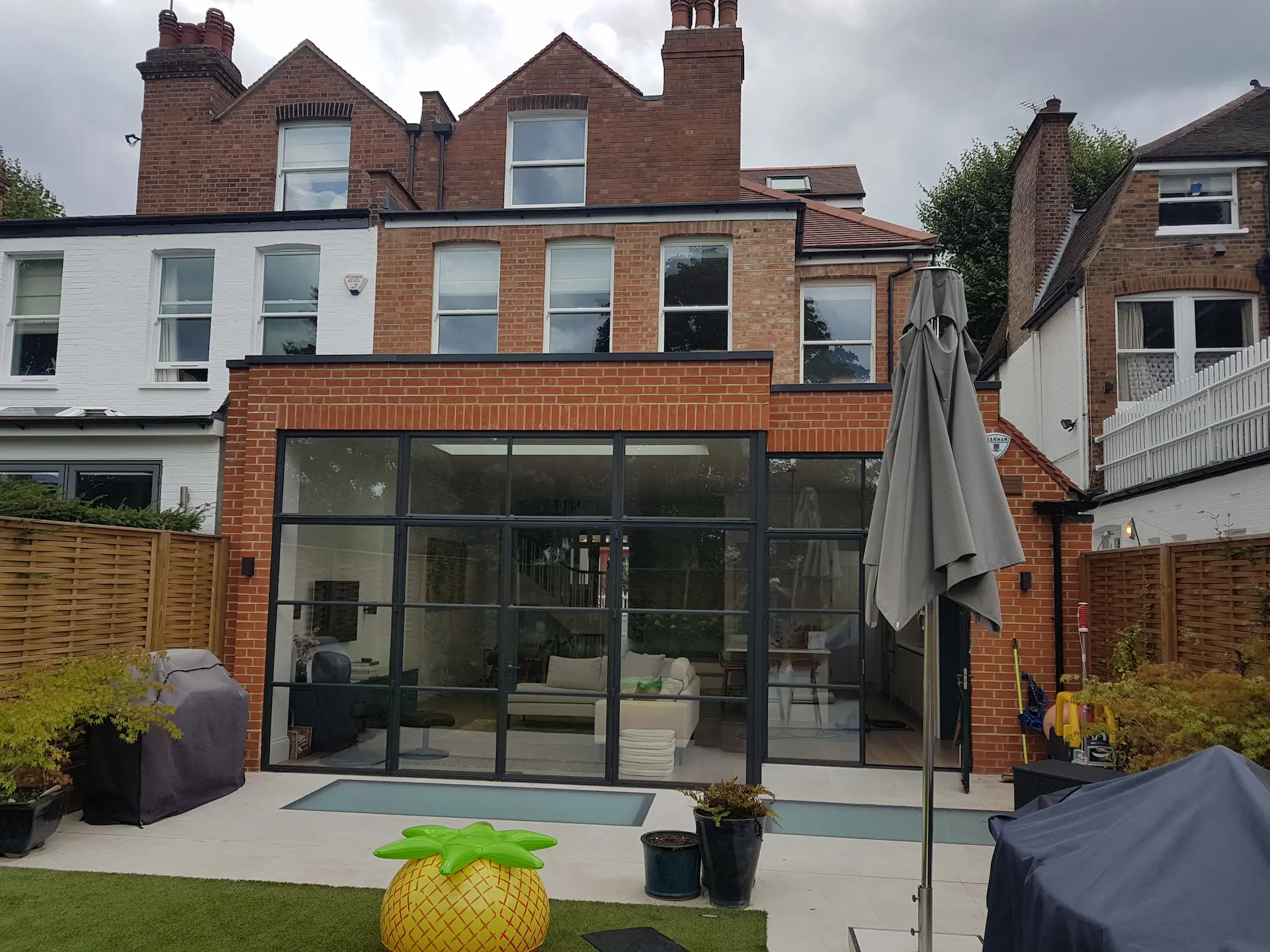 Completed rear elevation of west London home with Crittall door and floor lenses for natural light in the basement