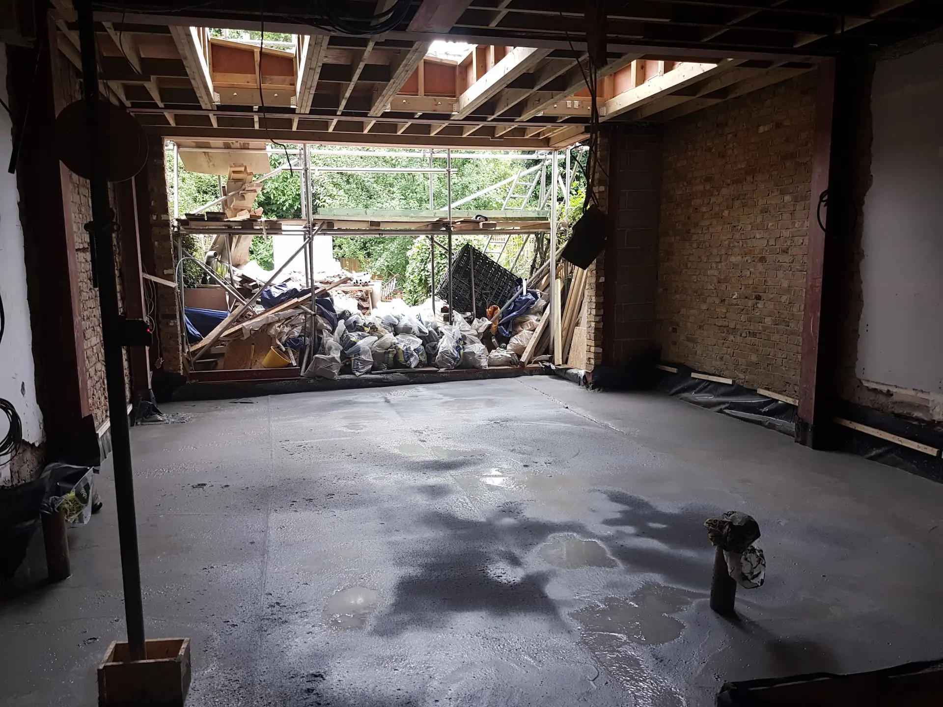 Open-plan area in an Ealing ground floor extension with freshly poured screed and upstands ready for skylight installation
